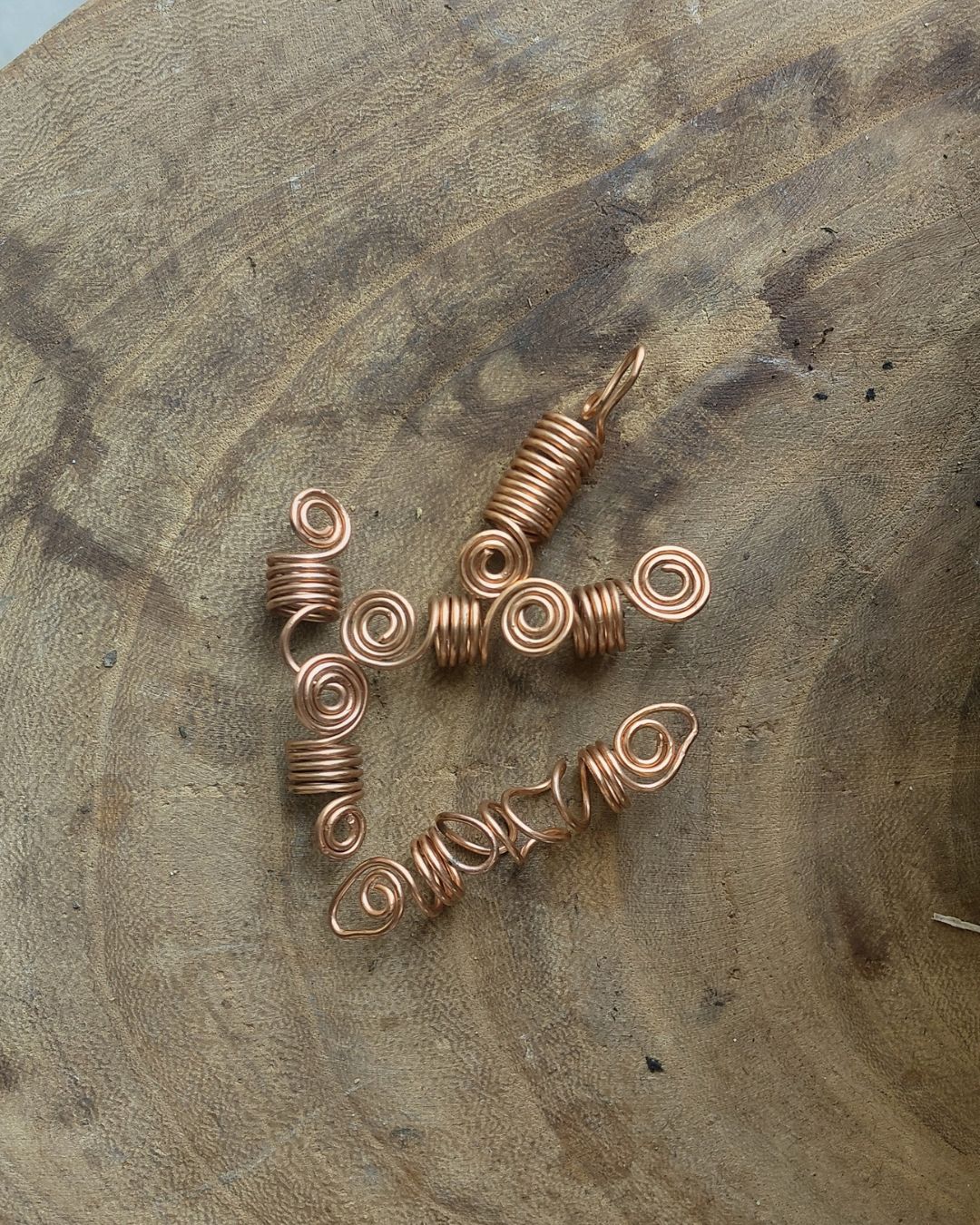 Extend your self-expression. Sleek, minimalist copper loc coils designed to embrace natural texture. Earthy hair jewelry, handmade in Lebanon at Sacred.